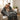 Couple sitting on a couch under a decorative blanket with Halloween-themed designs.