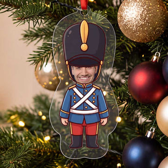 Personalized toy soldier photo ornament die-cut to the soldier shape in clear acrylic — a real face on a cute cartoon soldier body, on a red ribbon