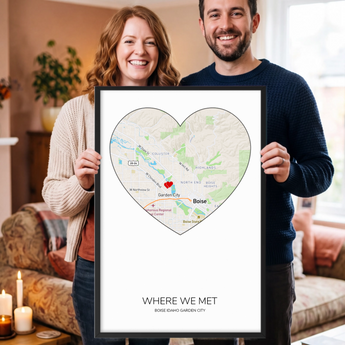 Framed personalized Where We Met map print — a custom Boise, Idaho street map shaped into a heart with a red heart marker, the couple's names, place and date, in a black wooden frame.
