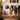Happy family standing on a beach house porch with a personalized metal sign that reads "The Jacksons" featuring a lighthouse and sailboat design – ideal custom decor for coastal homes or vacation retreats.