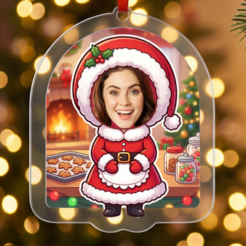 Personalized Mrs Claus Christmas ornament in clear acrylic — a real photo face on a cute cartoon Mrs Claus body baking in a cosy kitchen, on a red ribbon