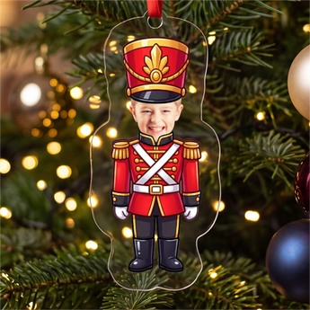 Personalized nutcracker photo ornament die-cut to the nutcracker shape in clear acrylic — a real face on a cute cartoon body, on a red ribbon