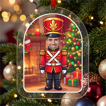 Personalized nutcracker Christmas ornament in clear acrylic — a real photo face on a cute cartoon nutcracker soldier body, on a red ribbon