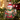 Personalized ugly Christmas sweater photo ornament die-cut to the jumper-and-hat shape in clear acrylic — a real face above a garish knitted Christmas sweater, on a red ribbon