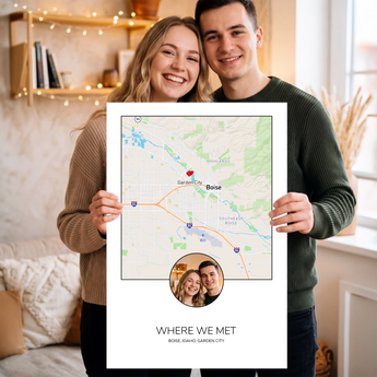 Couple holding an unframed personalized Where We Met map print — a Boise, Idaho street map with a red heart marker and their photo in a circle.
