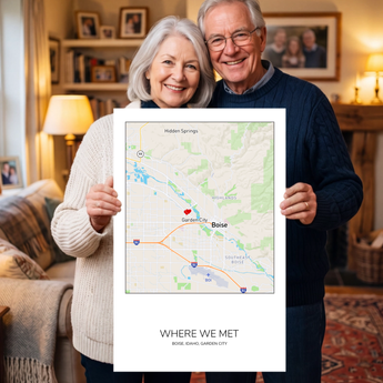 Couple holding an unframed personalized Where We Met map print — a Boise street map in a square with a red heart marker.