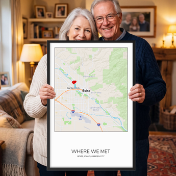 Framed personalized Where We Met map print — a custom Boise, Idaho street map in a square format with a red heart marker, the couple's names, place and date, in a black wooden frame.
