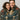 Two people hugging under a decorative blanket with skeletons and roses.