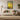 Personalized pet memorial poster displayed above a sofa in a cozy living room