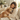 Woman hugging a golden retriever on a couch in a cozy living room.