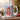Personalized cardinal photo mug on a cosy Christmas table — a real face on a cute cartoon red cardinal onesie with a green scarf, printed both sides