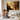 Two children kneeling on a bed in prayer beside an open Bible, with a Christian canvas wall art print of Jesus the Good Shepherd and a lamb displayed above them.