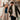 Couple walking arm in arm wearing winter outfits with man in cuban link chain necklace