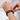 Closeup of hands adjusting black braided leather bracelet with stainless steel and gold-tone accent beads for a secure and stylish fit.