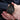 Black chronograph watch on wrist closeup with dotted dress shirt and clasped hands