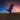 Silhouette of a couple embracing on a country road at sunset with a star-filled sky and shooting star overhead.