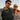 Smiling couple wearing sunglasses and gold and gemstone necklaces outdoors at sunset