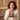 Woman smiling in surprise as she opens her personalized Alluring Beauty necklace gift — a keepsake for a sister, grandma or best friend.