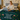 young woman sitting on bed using laptop while wrapped in personalized daughter woven blanket with you are your own power message