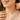 Close-up of woman smiling while wearing gold pendant necklace – luxury gift for her with elegant sparkle