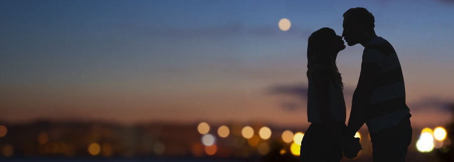 Romantic couple silhouette kissing at sunset under the moon with city lights in the background, perfect for wall art and home decor