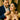 man gifting a gold heart necklace to smiling woman during romantic dinner