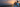 Man proposing at sunset on oceanfront deck holding gift box while surprising woman from behind